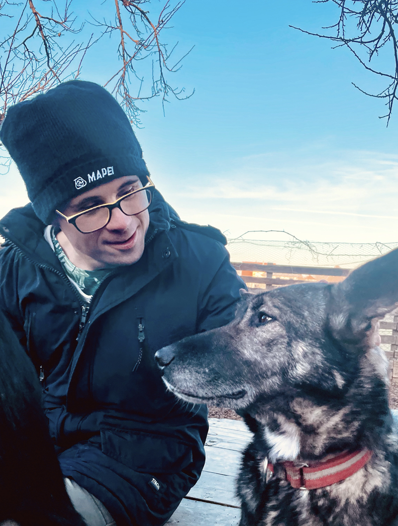 Huskyfieber Therapie Bild von einem jungen Mann mit besonderen Bedürfnissen, der neben einem Husky sitzt
